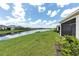 Lush backyard with pond view, manicured lawn, and tranquil setting creating a peaceful retreat at 407 157Th E Ct, Bradenton, FL 34212