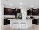 Well-equipped kitchen featuring dark cabinetry, granite countertops, and stainless steel appliances at 407 157Th E Ct, Bradenton, FL 34212