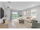 Bright living room with neutral tones, tile floors and sliding glass doors to backyard at 407 157Th E Ct, Bradenton, FL 34212
