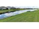 Scenic pond view reflecting sky and clouds, bordered by green grass and neighborhood homes at 407 157Th E Ct, Bradenton, FL 34212