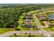 Scenic aerial perspective of a residential community with lush trees, sidewalks, and a pond at 408 166Th E St, Bradenton, FL 34212