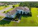 An elevated view of a house featuring lush landscaping, driveway, and a well-manicured lawn at 408 166Th E St, Bradenton, FL 34212