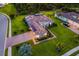 Aerial view of a landscaped property featuring a tile roof, solar panels, and brick driveway at 408 166Th E St, Bradenton, FL 34212