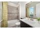 Bright bathroom featuring a tub with tile surround and a decorative shower curtain at 408 166Th E St, Bradenton, FL 34212