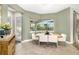 Bright breakfast nook with large window overlooking a screened lanai and modern white chairs at 408 166Th E St, Bradenton, FL 34212