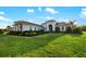 Spacious home with manicured lawn, landscaped garden beds, and a charming facade under a sunny sky at 408 166Th E St, Bradenton, FL 34212