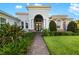 Charming home entrance with a decorative archway, double doors, and well-manicured landscaping at 408 166Th E St, Bradenton, FL 34212