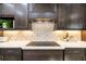 Modern kitchen featuring dark wood cabinets, a decorative backsplash, and white countertops at 408 166Th E St, Bradenton, FL 34212