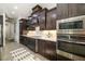 Gourmet kitchen features dark wood cabinets, stainless steel appliances, and stylish tile backsplash at 408 166Th E St, Bradenton, FL 34212