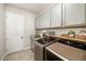 Well-organized laundry room with modern washer and dryer, ample storage and granite counters at 408 166Th E St, Bradenton, FL 34212