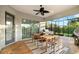 Covered patio with a dining table, ceiling fan, and outdoor kitchen area overlooking a tropical landscape at 408 166Th E St, Bradenton, FL 34212