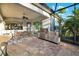 Covered patio with a stainless steel outdoor kitchen, dining table, and ceiling fan at 408 166Th E St, Bradenton, FL 34212