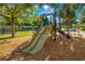 Community playground with a slide, surrounded by trees and wood chips at 408 166Th E St, Bradenton, FL 34212