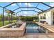 Screened pool and spa surrounded by brick-paved deck with lounge chairs and lush landscaping at 408 166Th E St, Bradenton, FL 34212