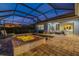 Illuminated pool and attached spa with brick-paved patio, screened enclosure, and outdoor seating at 408 166Th E St, Bradenton, FL 34212