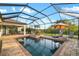 Sparkling swimming pool within a screened enclosure, complete with a spa, sun loungers, and outdoor seating at 408 166Th E St, Bradenton, FL 34212