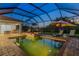 Screened pool area featuring a brick-paved deck, lounge chairs, and outdoor dining set at 408 166Th E St, Bradenton, FL 34212