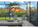Relaxing poolside view with lounge chairs, an umbrella, and lush greenery beyond the screened enclosure at 408 166Th E St, Bradenton, FL 34212
