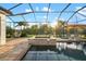 Tranquil screened-in pool area with a spa, hammock chair, and scenic views of the surrounding landscape at 408 166Th E St, Bradenton, FL 34212