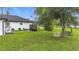 The backyard features a mature tree, artificial turf, a grill, and comfortable seating area for relaxation at 4148 Lobelia St, North Port, FL 34286