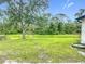 Expansive backyard features lush green grass, mature trees, and outdoor seating for relaxing enjoyment at 4148 Lobelia St, North Port, FL 34286