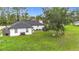 The large backyard features lush lawn, seating, the home's exterior, and plenty of room for outdoor enjoyment at 4148 Lobelia St, North Port, FL 34286