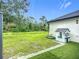 Backyard featuring a playhouse and swing with lawn extending to a natural area at 4148 Lobelia St, North Port, FL 34286