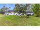 The expansive backyard features lush grass and mature trees offering shaded relaxation and outdoor enjoyment at 4148 Lobelia St, North Port, FL 34286