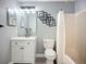Bathroom featuring a modern vanity, toilet, decorative mirror, and framed squares at 4148 Lobelia St, North Port, FL 34286
