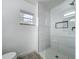 Walk-in shower featuring glass partition and bright neutral tile at 4148 Lobelia St, North Port, FL 34286