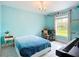 Bright bedroom with blue walls, chandelier, and a writing desk at 4148 Lobelia St, North Port, FL 34286