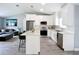 Modern open kitchen showcasing white cabinets, a kitchen island, and stainless steel appliances with an open living room at 4148 Lobelia St, North Port, FL 34286