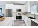 Well-lit kitchen featuring white cabinetry, stainless steel appliances, quartz countertops and lovely backsplash at 4148 Lobelia St, North Port, FL 34286