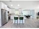 Bright, open kitchen featuring white cabinetry, a kitchen island with seating, and modern stainless steel appliances at 4148 Lobelia St, North Port, FL 34286