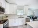 Bright kitchen featuring white cabinetry, stainless steel appliances, and stylish backsplash at 4148 Lobelia St, North Port, FL 34286
