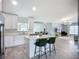 Bright, open kitchen with white cabinetry, quartz countertops, an island with seating, and stainless steel appliances at 4148 Lobelia St, North Port, FL 34286