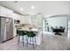 Modern, open kitchen showcasing white cabinetry, an island with seating, stainless steel appliances, and plank flooring at 4148 Lobelia St, North Port, FL 34286
