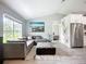 Spacious living room with vaulted ceilings and modern gray sectional sofa, and a large picture window at 4148 Lobelia St, North Port, FL 34286