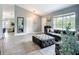 Comfortable living room featuring a plush gray sectional sofa, a large mirror, and light-filled window views at 4148 Lobelia St, North Port, FL 34286