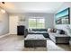 Inviting living room featuring a plush gray sectional sofa, accent furniture, and light-filled window views at 4148 Lobelia St, North Port, FL 34286