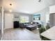 Bright open-concept living room with gray sectional, hard floors, and modern decor, filled with natural light at 4148 Lobelia St, North Port, FL 34286