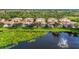 Aerial view featuring townhomes overlooking a beautiful lake with a fountain, and well-maintained landscaping at 4210 Vicenza Dr # D25, Venice, FL 34293