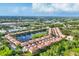 Beautiful aerial view of townhomes with a central lake featuring a fountain and lush landscaping at 4210 Vicenza Dr # D25, Venice, FL 34293