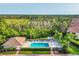 Aerial view of a community pool, clubhouse, and lush greenery with a view of the marsh at 4210 Vicenza Dr # D25, Venice, FL 34293