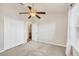 A cozy bedroom with beige walls, a ceiling fan, and a view into the bathroom at 4210 Vicenza Dr # D25, Venice, FL 34293