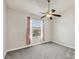 Carpeted bedroom with neutral walls, a ceiling fan, and a large window offering a relaxing and comfortable space at 4210 Vicenza Dr # D25, Venice, FL 34293