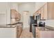 Modern kitchen featuring wood cabinets, granite countertops, and stainless steel appliances at 4210 Vicenza Dr # D25, Venice, FL 34293
