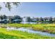 Scenic water view featuring a tranquil pond and fountain surrounded by lush green grass and mature trees at 4210 Vicenza Dr # D25, Venice, FL 34293