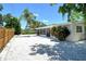 This charming backyard features a screened in porch, a palm tree, and privacy fence at 4214 Groveland Ave, Sarasota, FL 34231