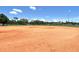 Wide shot of the Community baseball field and outfield on a bright day with blue sky and fluffy clouds at 4214 Groveland Ave, Sarasota, FL 34231